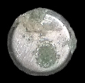 Undecorated round silver button face with copper alloy corrosion from 18AN339 Java Site.